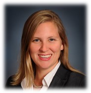 A woman in business attire smiling for the camera.