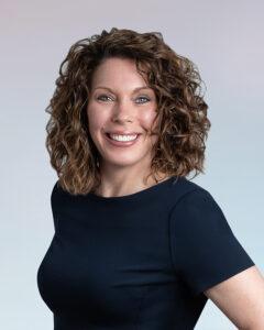 A woman with curly hair and blue eyes.