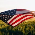 A flag flying in the middle of a field.