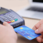 A person holding a credit card in their hand.